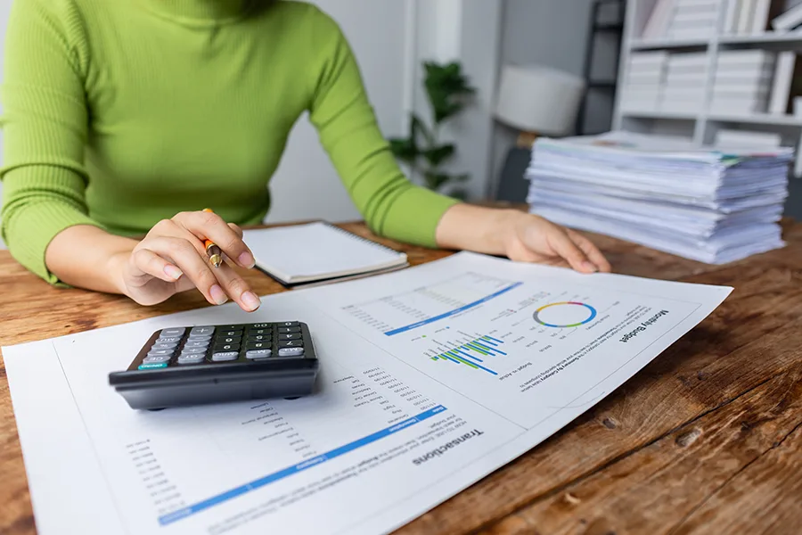 Personne faisant ses compte et sa gestion de budget à l'aide d'une calculatrice