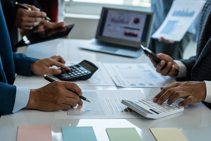 plusieurs personnes travaillant sur un bureau -graphiques, calculatrices)