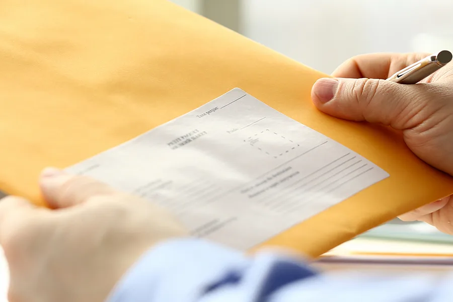 Photo d'une personne tenant une enveloppe dans les mains